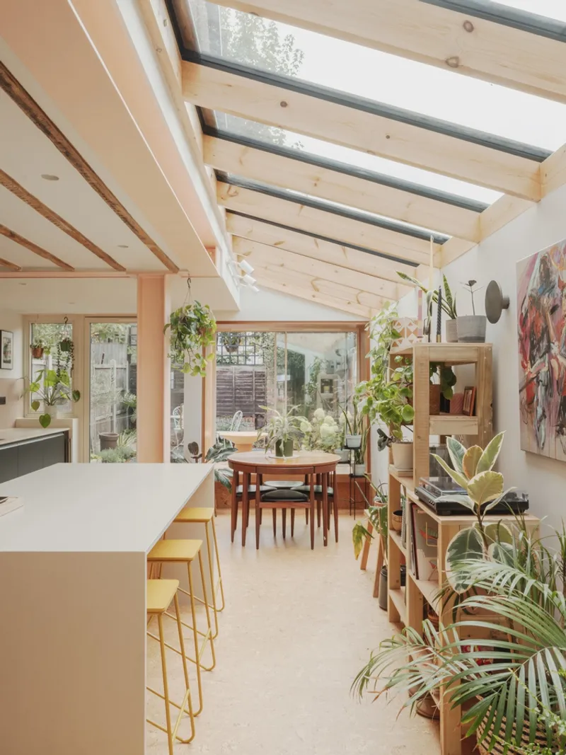 Interior view through the kitchen and dining area with skylights and exposed timber beams above