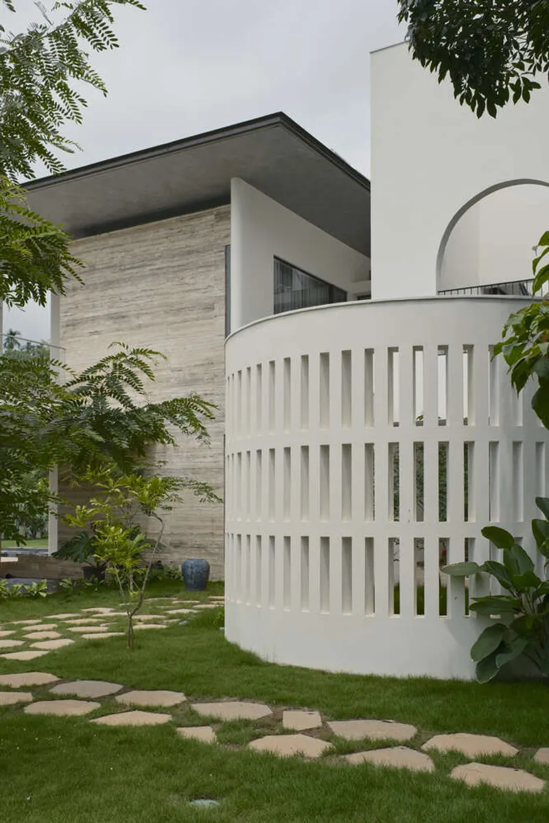Curved white slatted screen wall beside a stepping stone path through the lawn