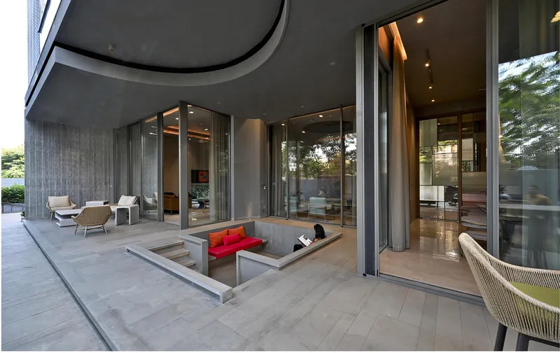 Sunken seating area with glass walls opening to covered terrace at dusk