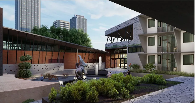 Central courtyard with a bronze sculpture, planted beds, and perforated bridge overhead