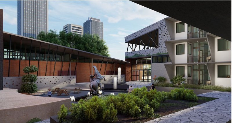 Central courtyard with a bronze sculpture, planted beds, and perforated bridge overhead