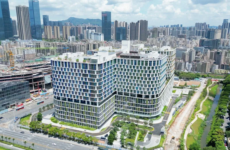 Aerial view of the twin curved glass towers surrounded by landscaped pathways and a canal