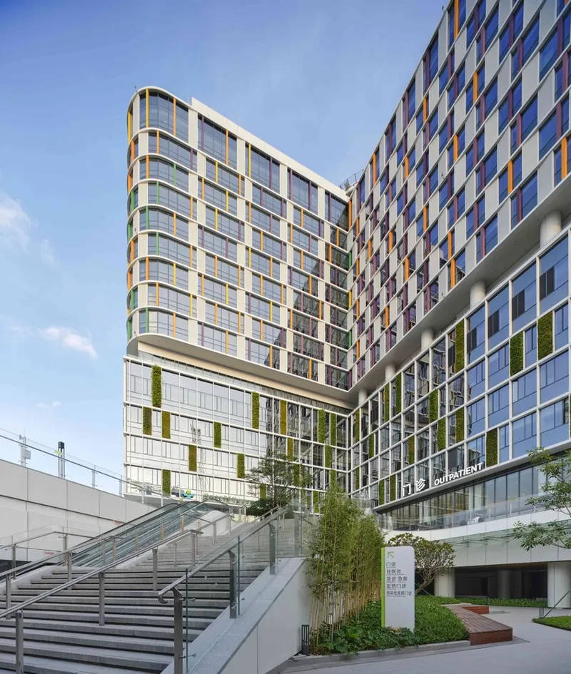 Exterior staircase ascending to a landscaped terrace beneath the cantilevered glass and panel facade