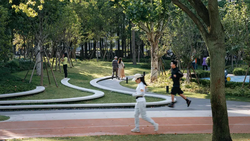 Winding concrete paths threading through lawns and trees as joggers and pedestrians move through dappled sunlight