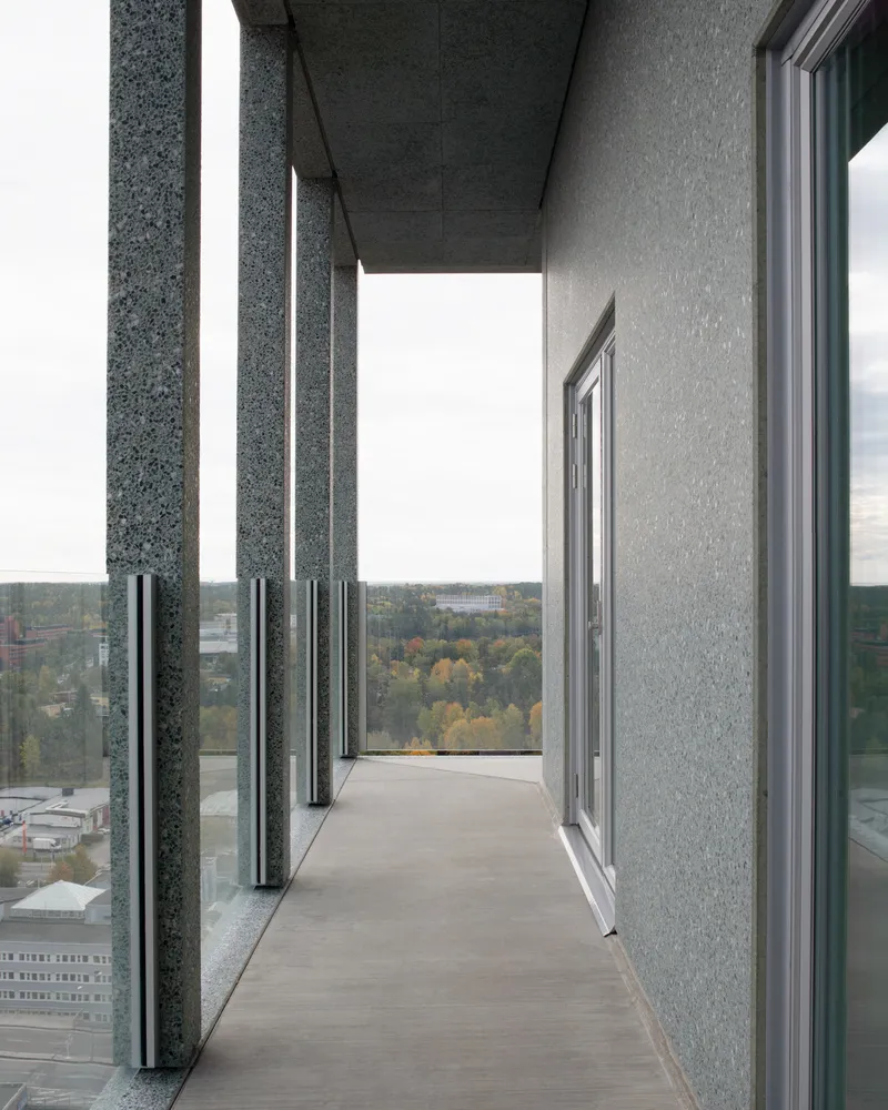 Balcony with alternating dark and light precast concrete columns under an overhanging soffit