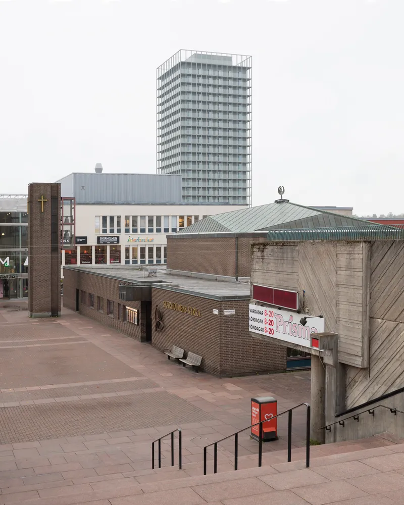 Elevated view of the paved plaza looking toward the tower and surrounding low-rise buildings