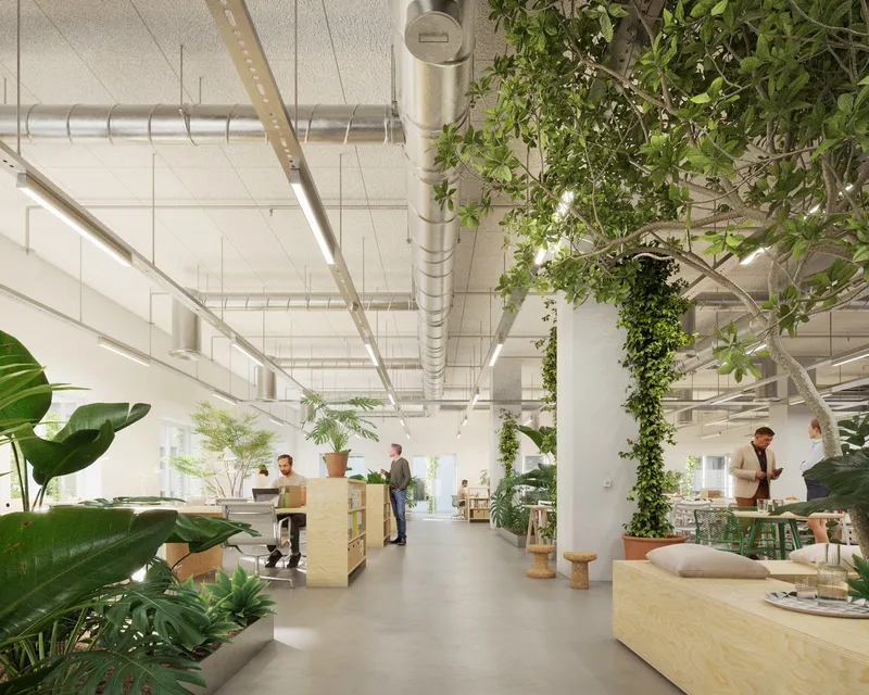 Open office floor with vine-covered columns, exposed ductwork and pendant lights hanging from a white gridded ceiling