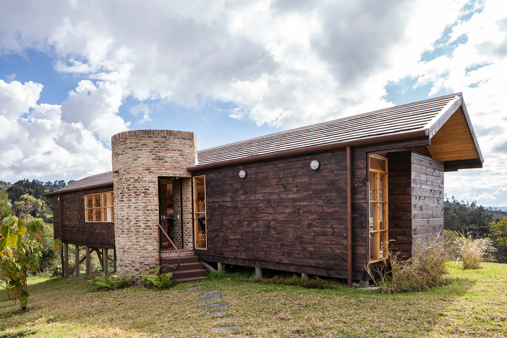 Yemail Arquitectura Anchors a Timber Cabin and Brick Tower in Colombia's Rolling Highlands