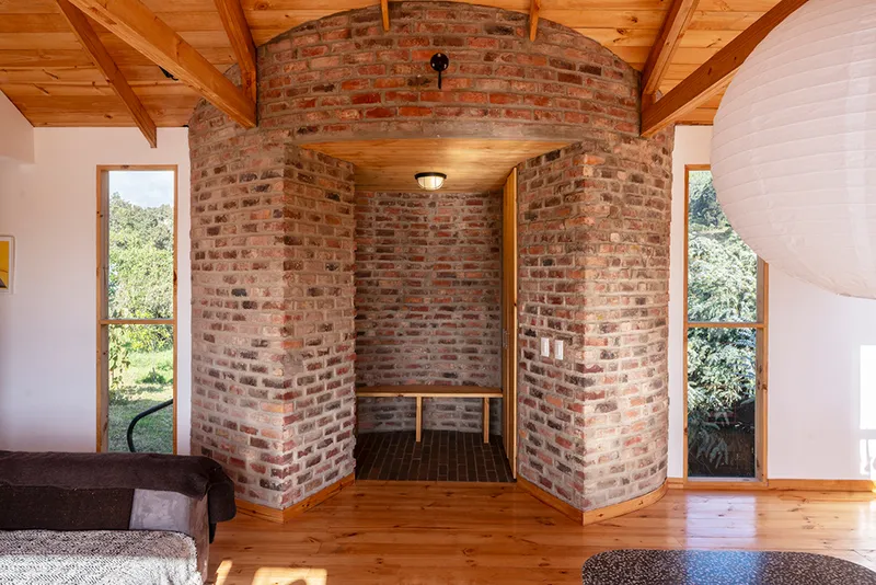 Interior brick alcove with vaulted masonry arch framed by tall narrow windows