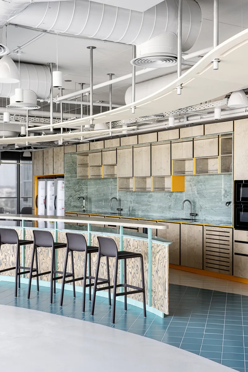 Breakfast bar with turquoise tile base and mint green marble backsplash under exposed ductwork