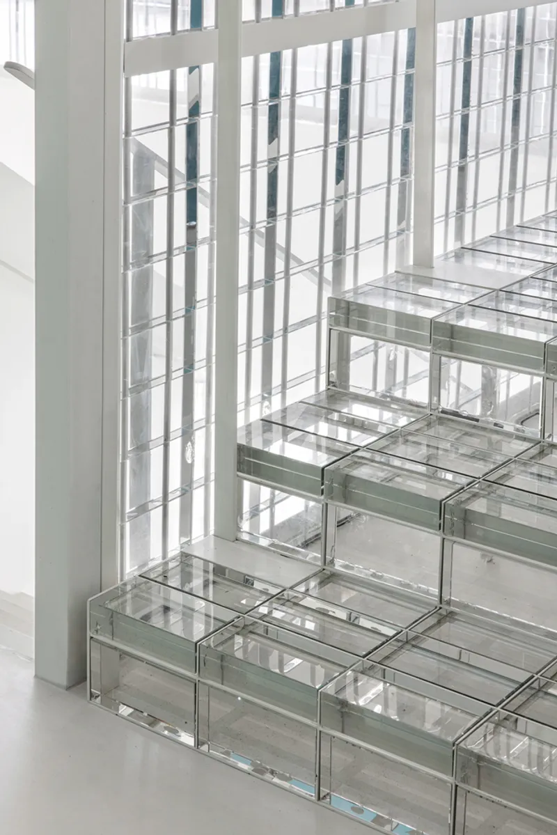 Detail of glass block stair treads meeting a vertical translucent screen wall