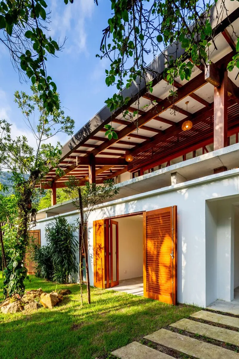 Entry level with timber pergola, louvered shutters, and stepped stone pathway through planted lawn