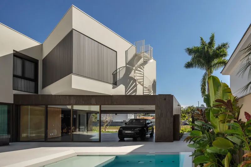 Rear elevation showing the carport structure, external spiral stair, and poolside terrace with palm trees