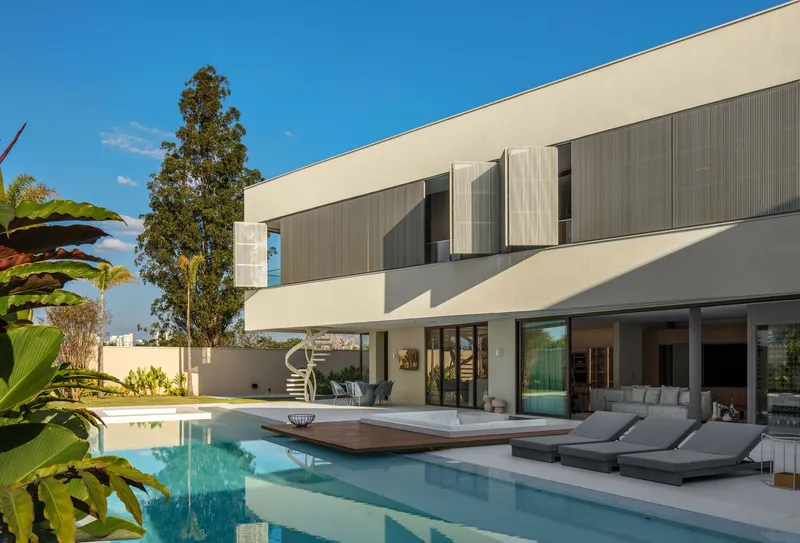 Pool deck with timber platform extending over water beneath upper level timber screens