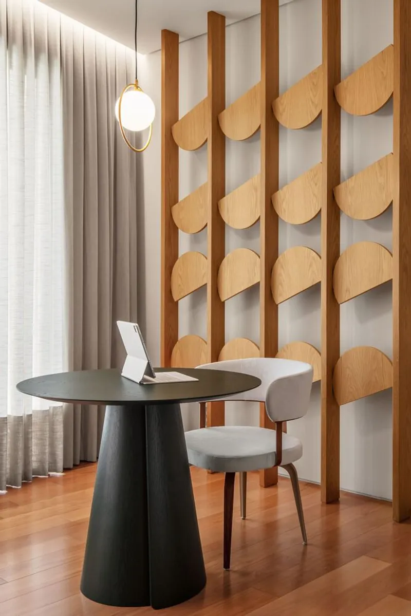 Dining nook with scalloped wood panel screen, pendant light, and sheer curtains