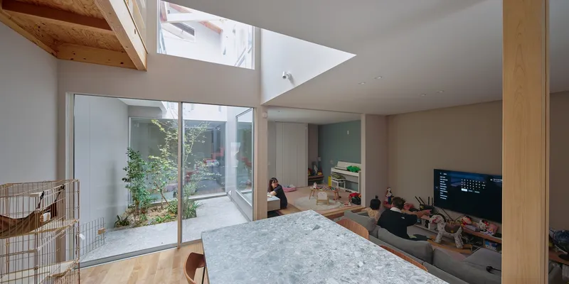 Living space with exposed timber column looking down to the courtyard garden through glazed walls