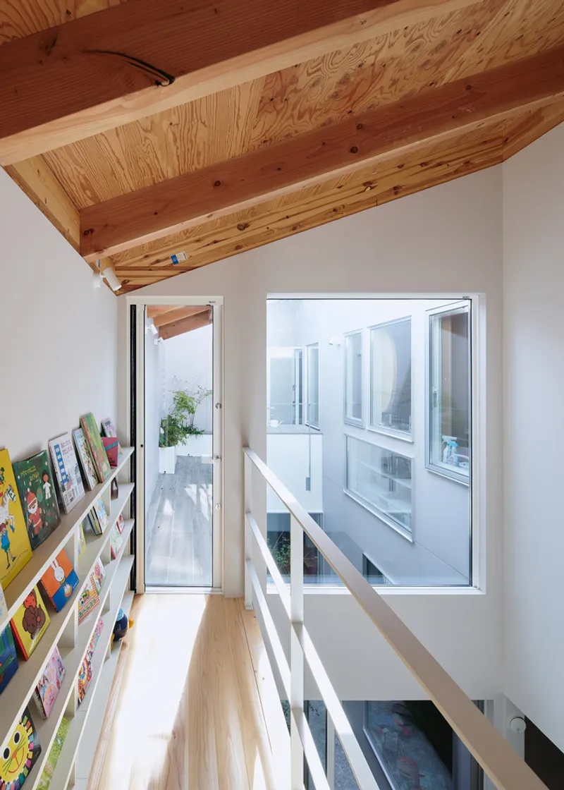 Reading nook with white book shelves and glazed doors opening to a courtyard
