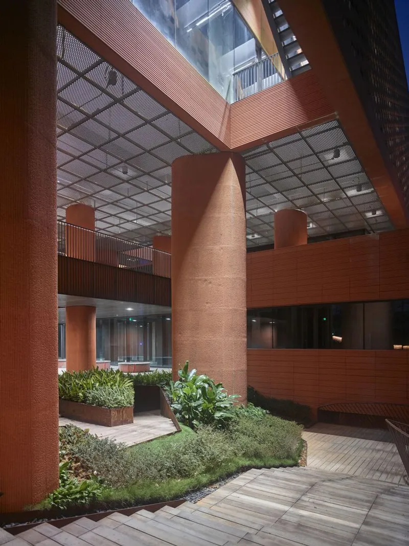 Interior atrium with cylindrical terracotta columns, planted beds and perforated metal ceiling grid