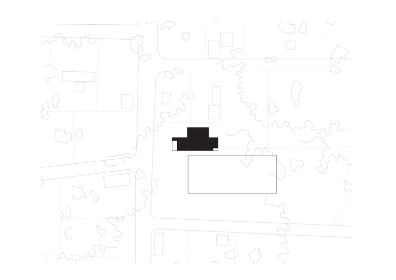 Site plan drawing showing a compact building footprint surrounded by organic tree canopies and neighboring structures