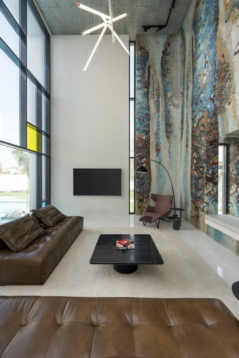 Living room with exposed concrete ceiling, textured tile wall and ribbon window opening to lawn
