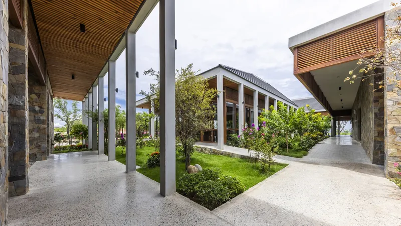 Covered walkways framing a central courtyard garden with gravel paths and planted beds