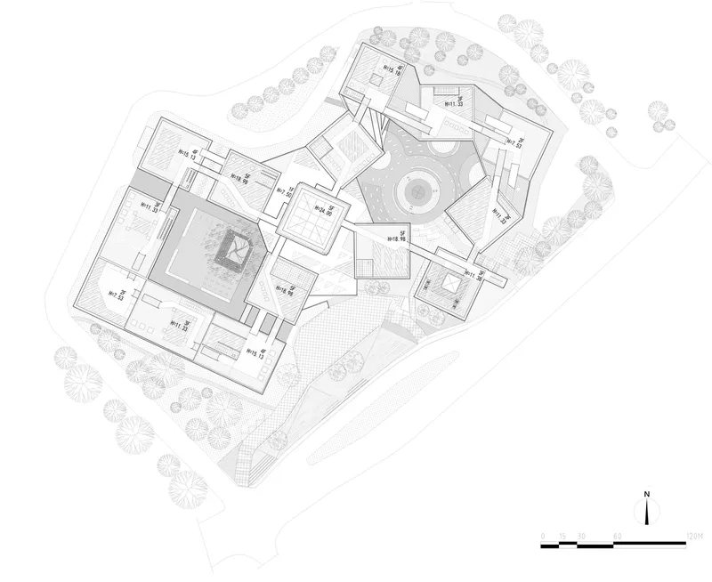 Site plan drawing showing clustered rectangular volumes around two circular courtyards with surrounding trees