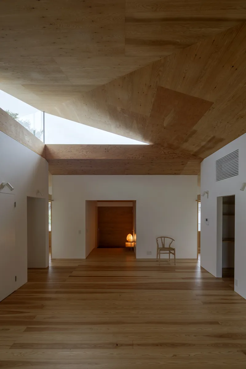 Central hallway with vaulted plywood ceiling and clerestory window admitting natural light