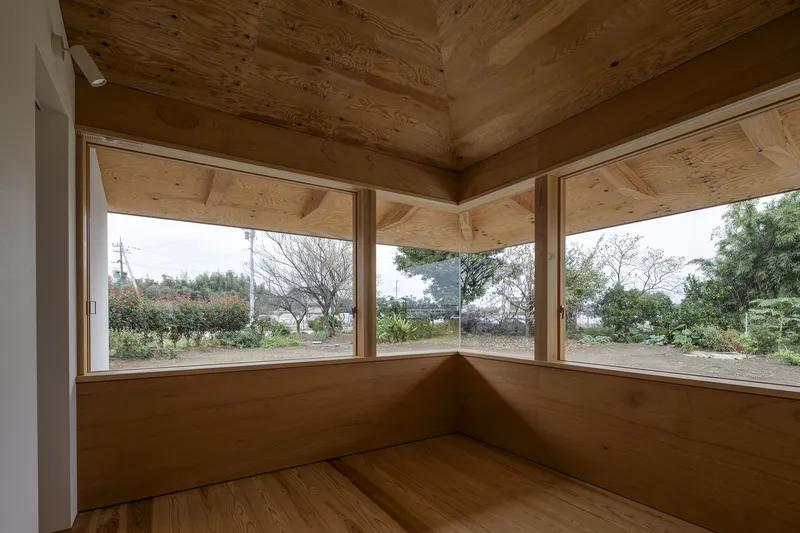 Corner window seat with timber-lined walls and ceiling overlooking bare winter trees