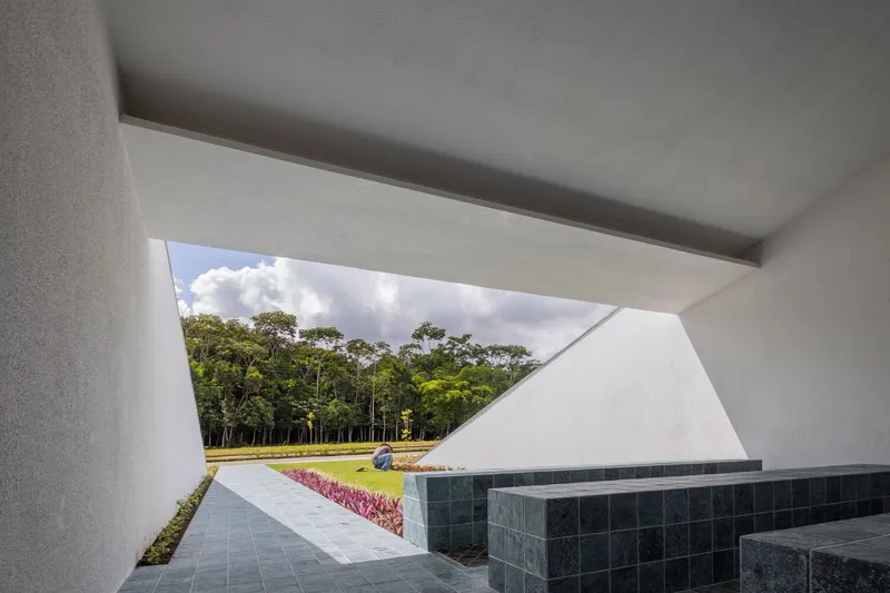 Angled opening framing lawn and planted beds with dark stone steps in foreground under clouded sky