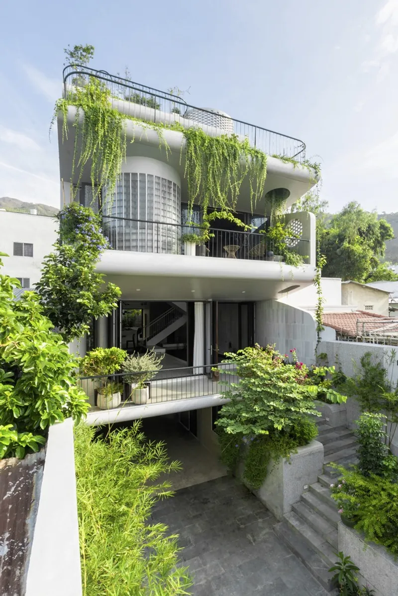 Stacked terraces with hanging greenery and concrete stairs descending through the garden