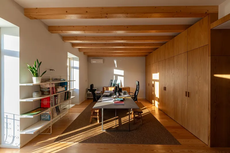 Study area with timber wall paneling and exposed ceiling beams in afternoon sunlight