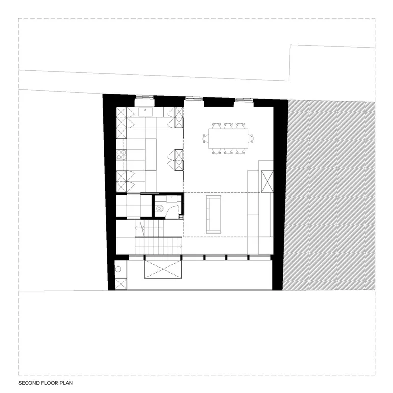Second floor plan drawing showing kitchen, dining area and central circulation with stairwell descending below