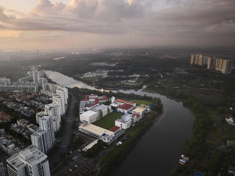 Drone view of the campus surrounded by river meanders and forests at sunset