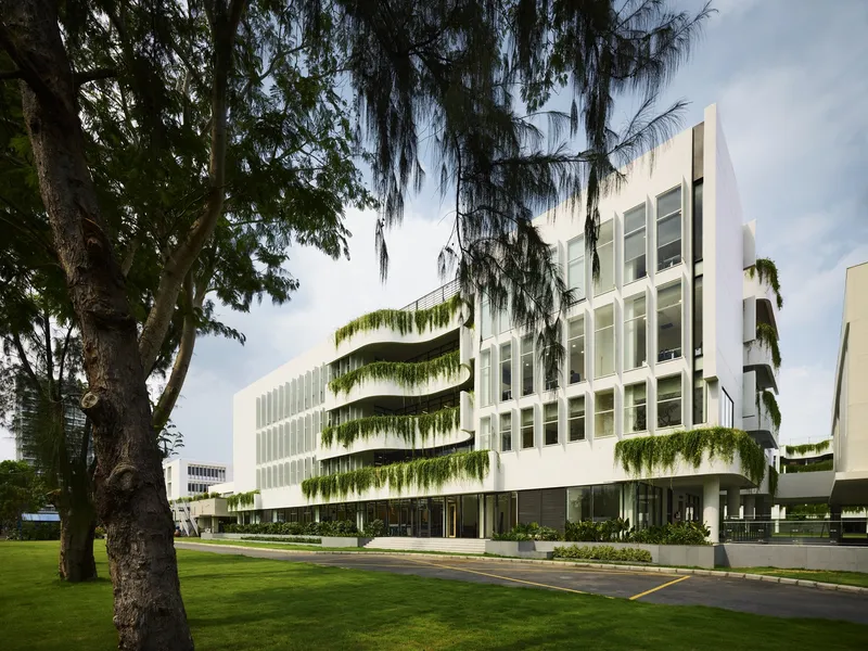 White facade with cascading planters viewed from lawn beneath mature trees