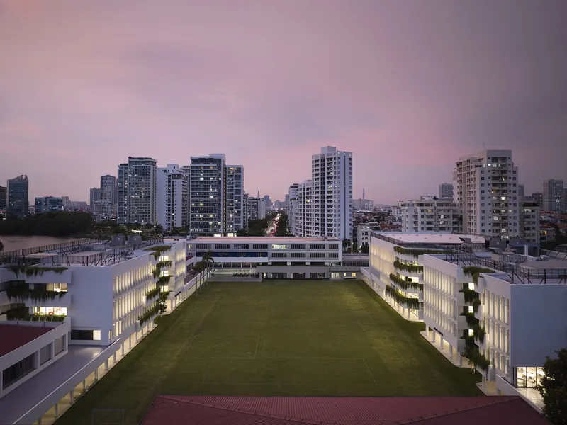 Aerial view of the courtyard sports field surrounded by lit buildings at twilight
