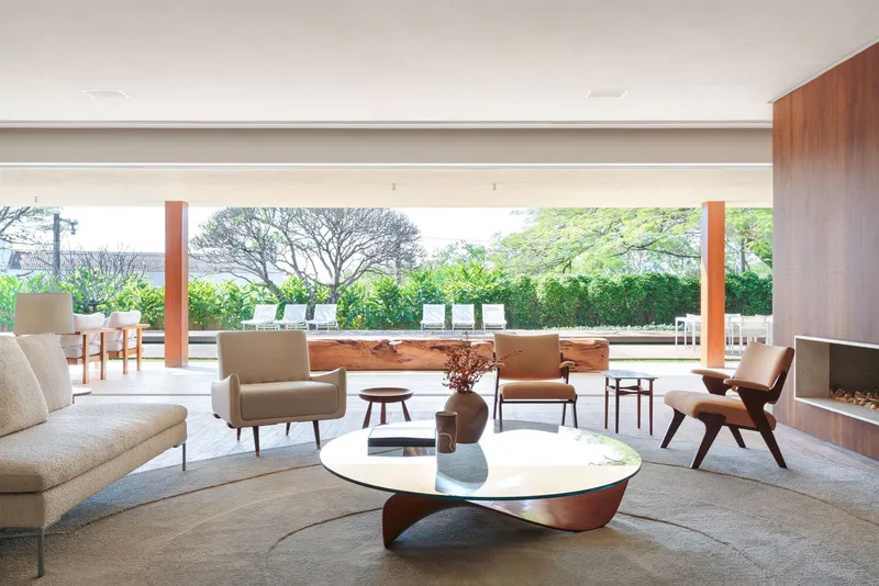Open living area with timber columns framing views of the pool and mature trees beyond