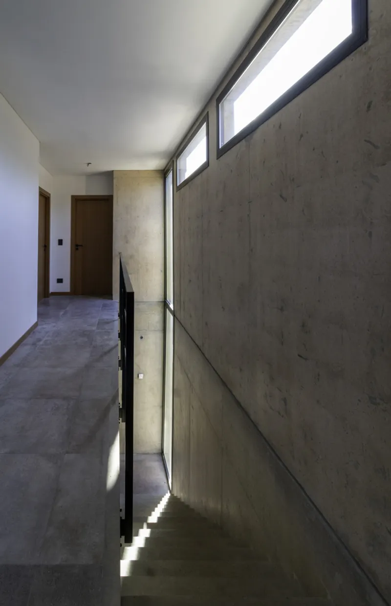 Upper hallway with clerestory windows above a glass balustrade overlooking the stairwell below