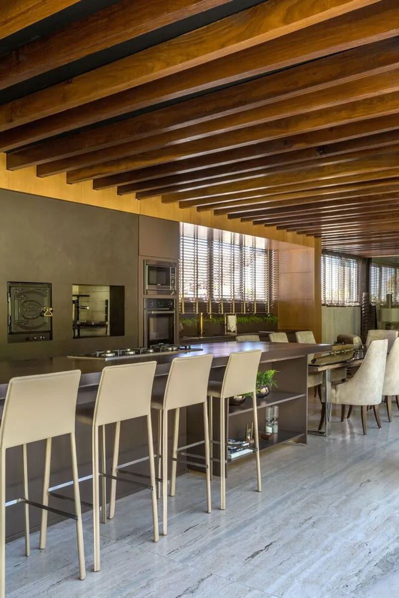 Kitchen island with bar seating under exposed timber beam ceiling with steel joists