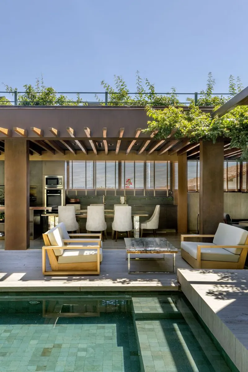 Terrace pavilion beside the tiled pool with steel column, timber beams, and rooftop planting under clear sky