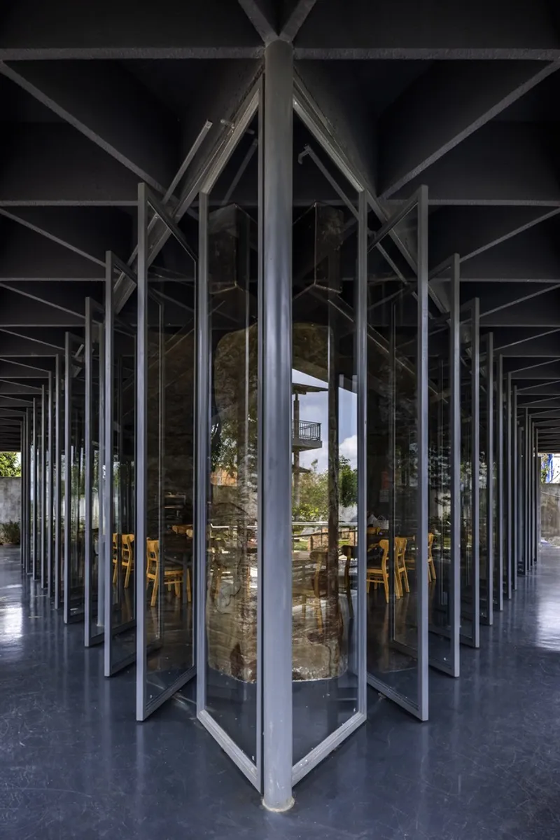 Interior perspective through pivoting glass doors with vertical steel mullions and views to the courtyard beyond