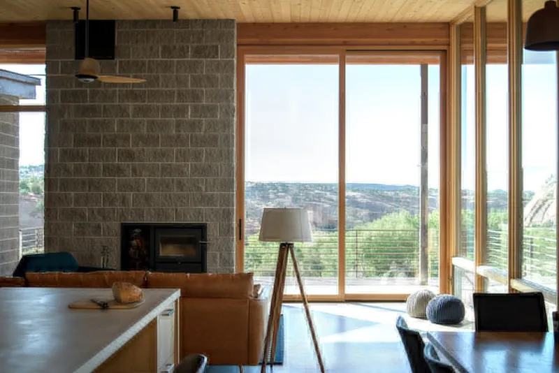 Open kitchen and dining area with concrete block fireplace wall and sliding glass doors to the terrace