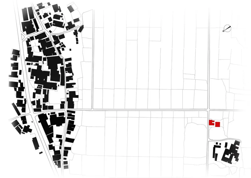 Site plan drawing with the building highlighted in red among surrounding urban fabric and agricultural plots