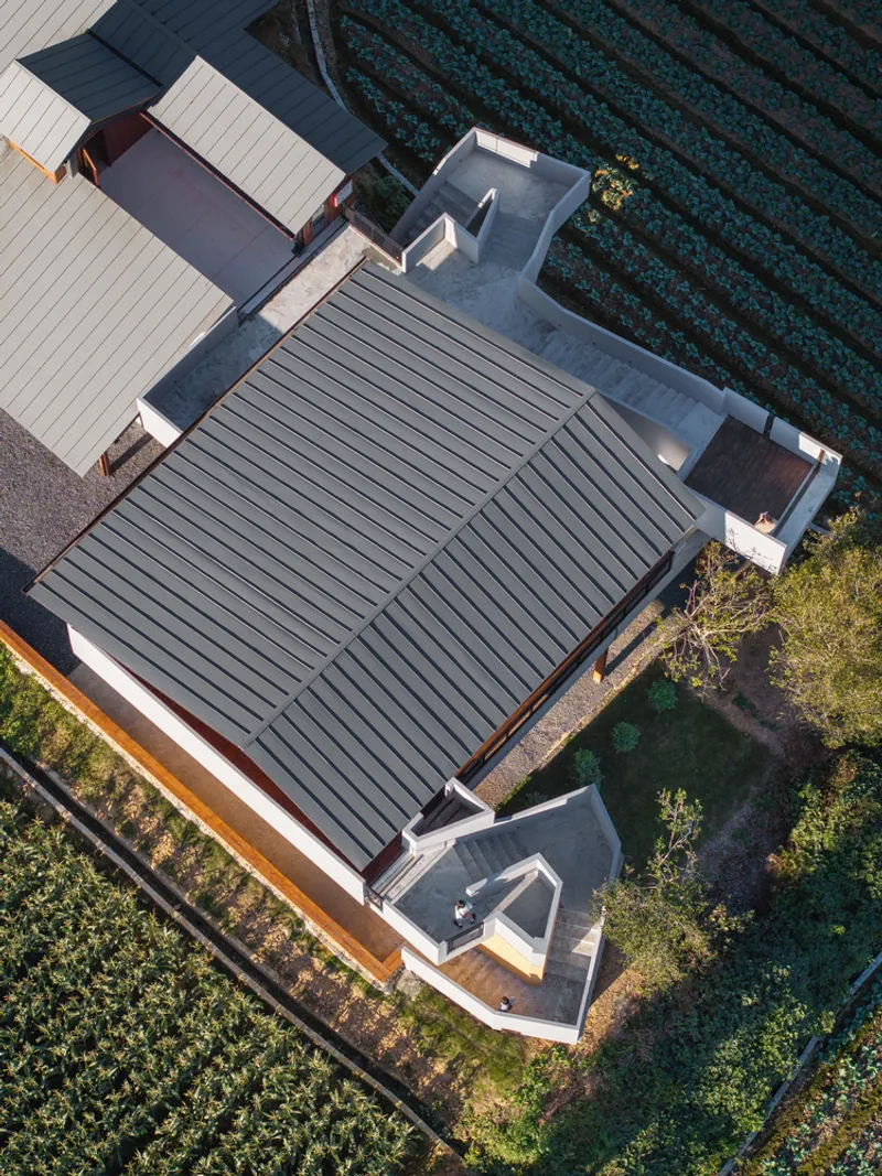 Aerial view of the standing seam metal roof and white courtyards surrounded by farmland