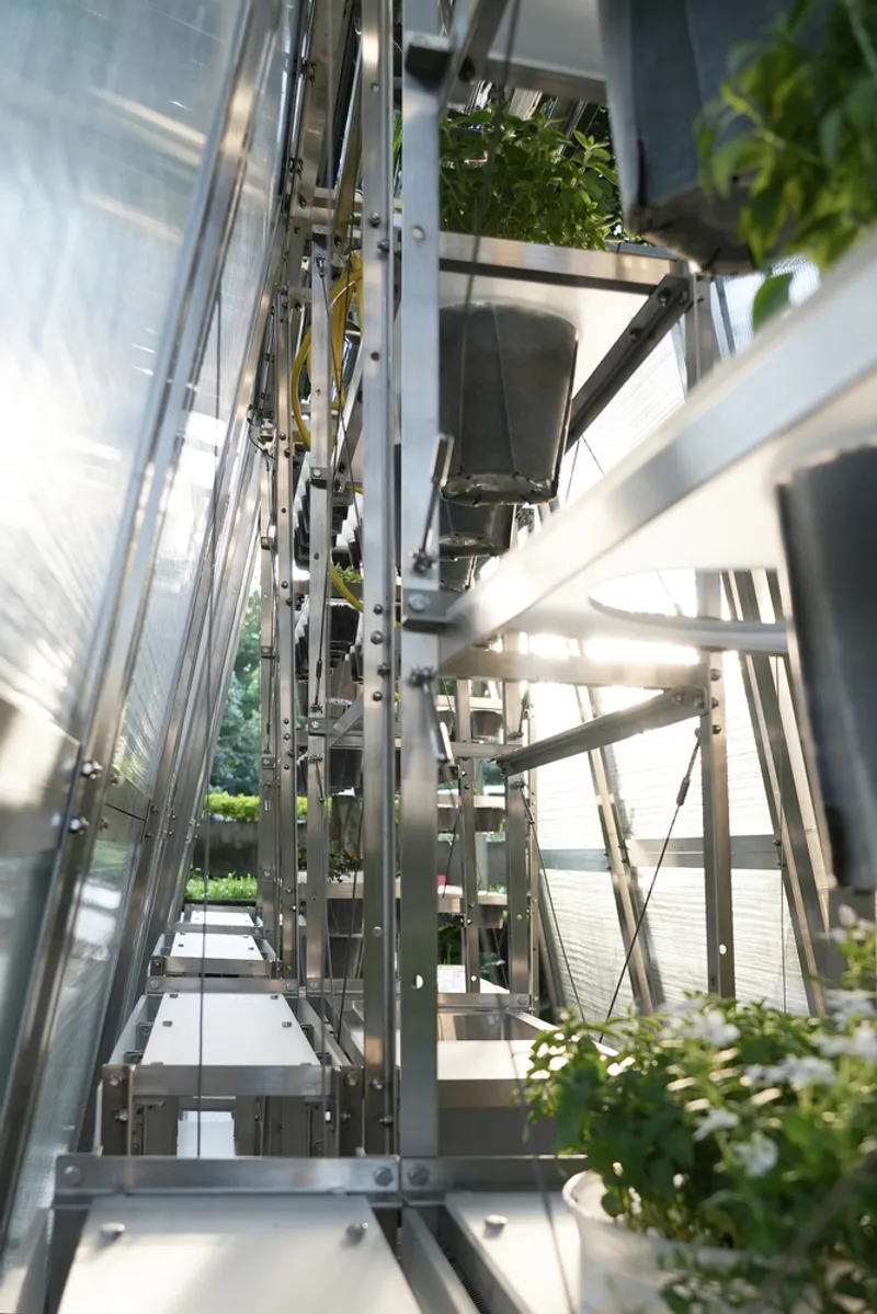 Vertical view up through the central core of the aluminum frame with planted shelves on either side
