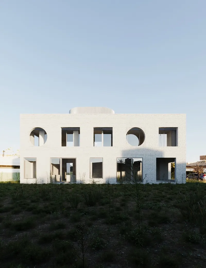 White rendered facade with circular and rectangular window openings in young landscaped grounds