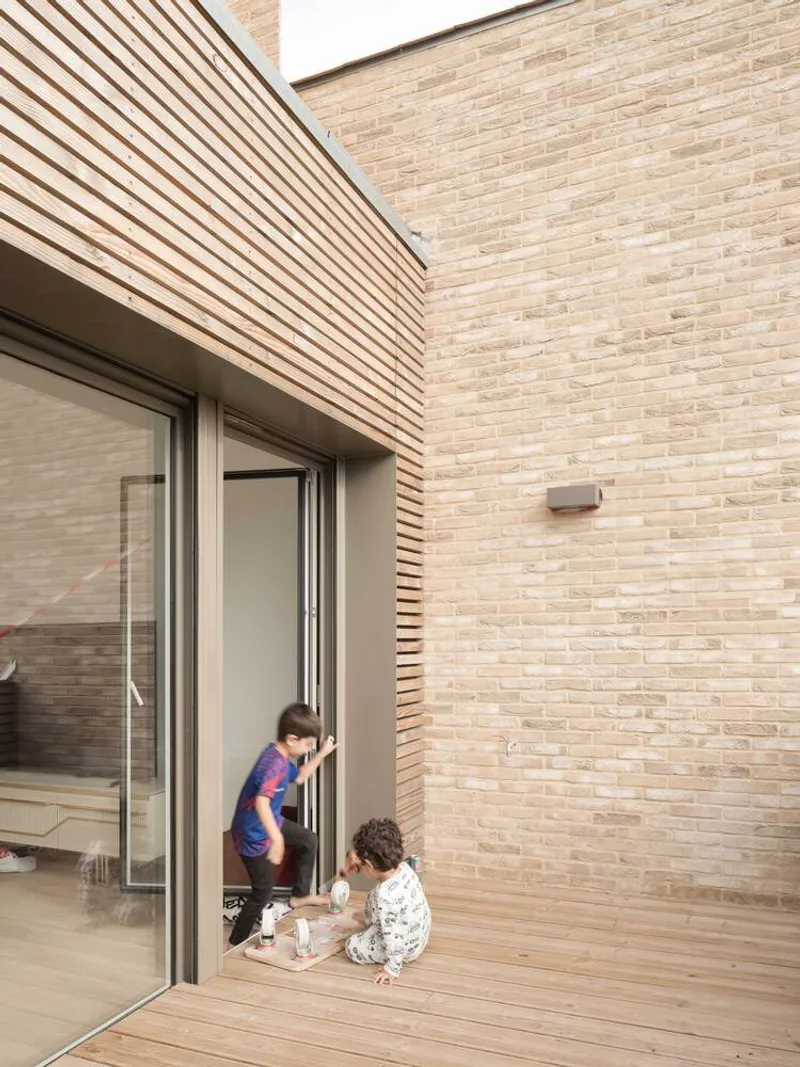Private terrace with timber decking and two children near the sliding glass door