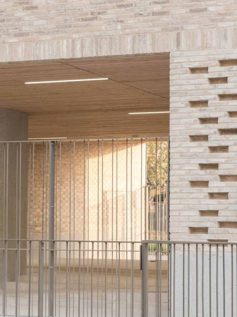 Floating timber staircase ascending alongside a pale brick wall with vertical metal railings below