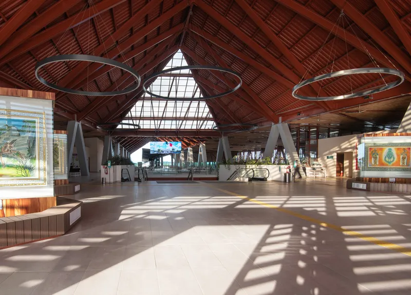 Main concourse showing timber lattice ceiling with triangular skylight and circular pendant lights casting shadows