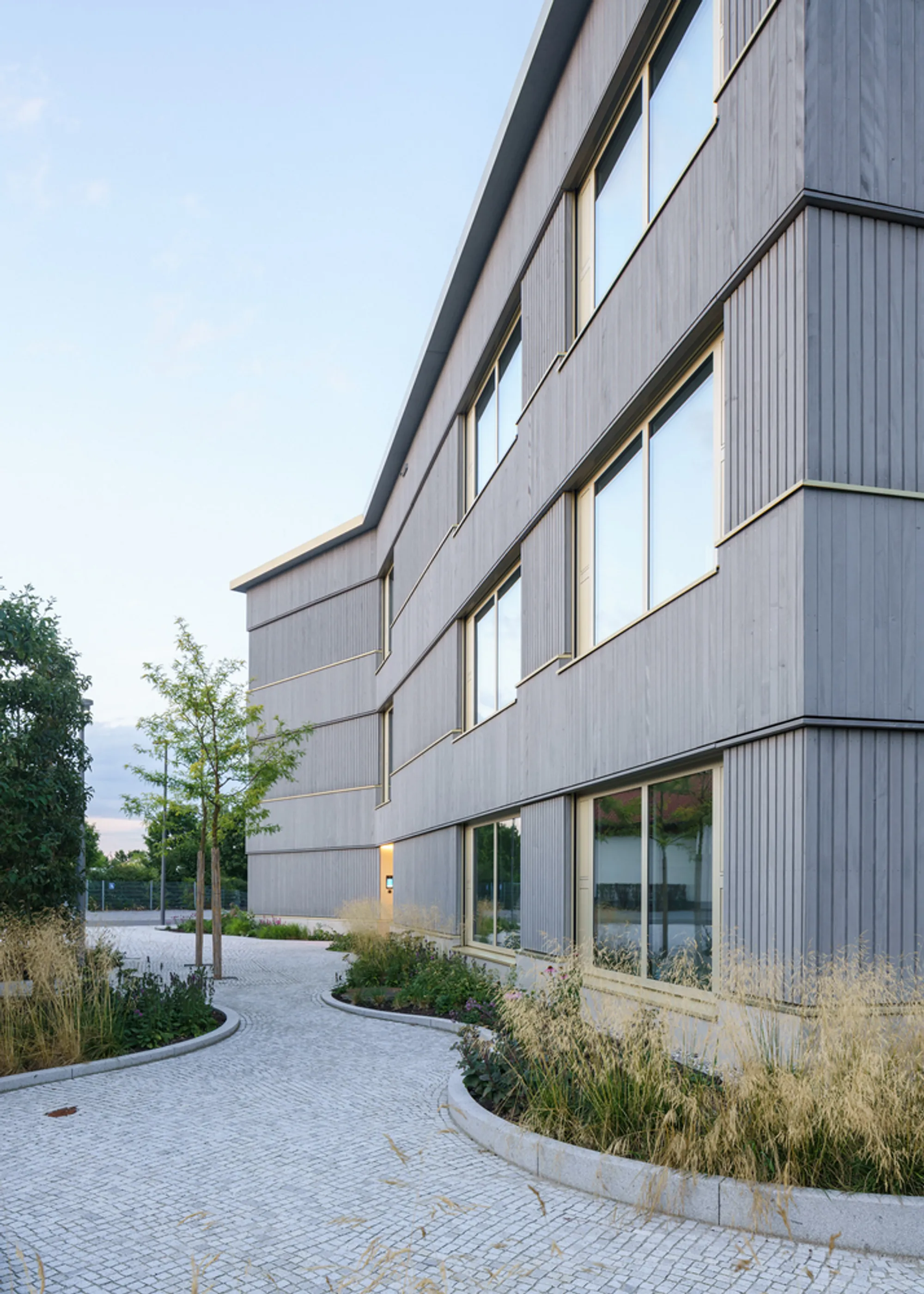 nbundm* Wraps a Three-Wing Office Building in Ribbed Cladding and Coral Accents Outside Munich