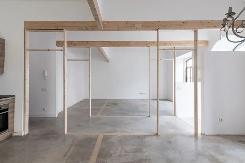 Light timber frame partition with exposed ceiling beams and polished concrete flooring throughout the interior